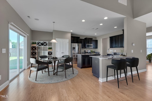 615 Fairway Dr, Mebane, NC 27302 - kitchen featuring appliances with stainless steel finishes, light wood-style floors, healthy amount of natural light, a breakfast bar, and recessed lighting