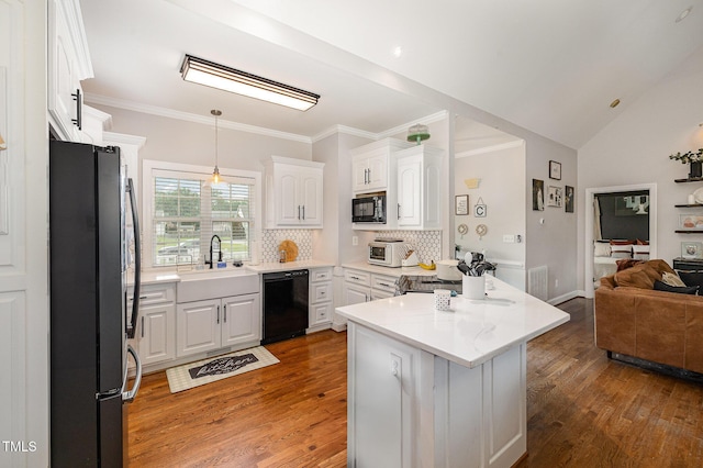 305 Maddux Dr, Pikeville, NC 27863 - kitchen with black appliances, open floor plan, wood finished floors, white cabinetry, and decorative backsplash