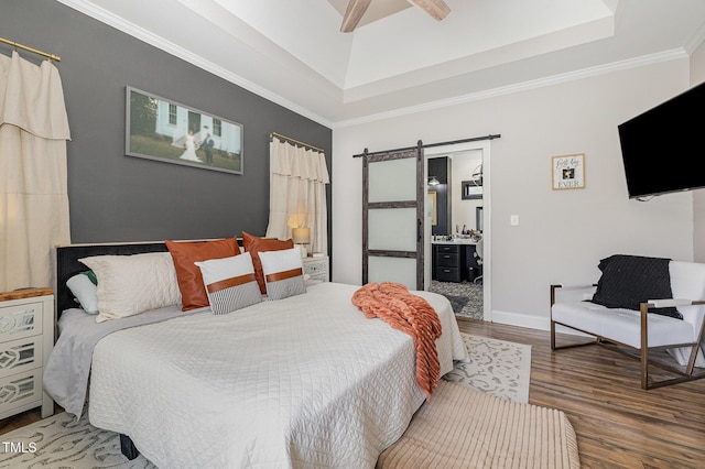 305 Maddux Dr, Pikeville, NC 27863 - bedroom featuring a barn door, wood finished floors, a tray ceiling, ornamental molding, and ensuite bath