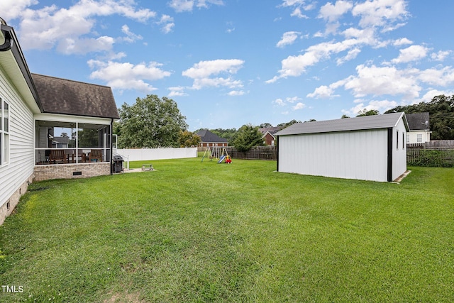 305 Maddux Dr, Pikeville, NC 27863 - fenced backyard featuring a playground, a storage unit, and a sunroom