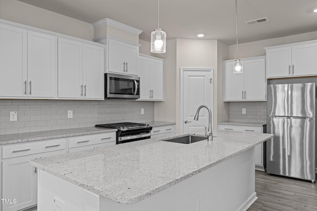 348 Abbots Mill Dr, Raleigh, NC 27603 - kitchen with appliances with stainless steel finishes, white cabinetry, a center island with sink, pendant lighting, and recessed lighting