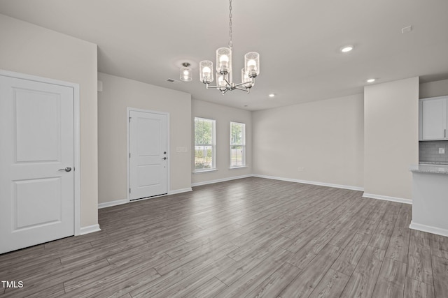 348 Abbots Mill Dr, Raleigh, NC 27603 - unfurnished living room featuring a chandelier, light wood-style flooring, and recessed lighting