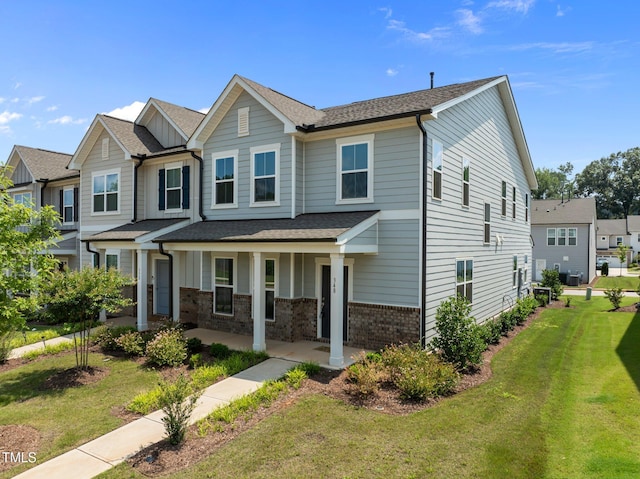 348 Abbots Mill Dr, Raleigh, NC 27603 - view of front of property with a front yard, covered porch, brick siding, board and batten siding, and roof with shingles