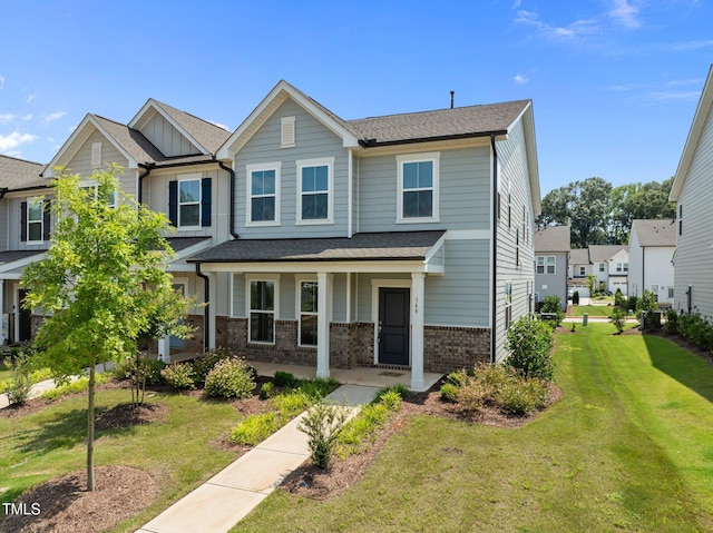 348 Abbots Mill Dr, Raleigh, NC 27603 - view of front facade with a porch, brick siding, a front lawn, board and batten siding, and a shingled roof