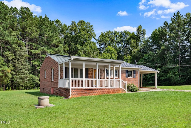 7060 Dirgie Mine Rd, Roxboro, NC 27574 - view of front facade featuring covered porch, a front lawn, brick siding, a metal roof, and a carport