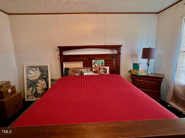 174 Daffodil Dr, Henderson, NC 27537 - bedroom with crown molding, a textured ceiling, and wood finished floors
