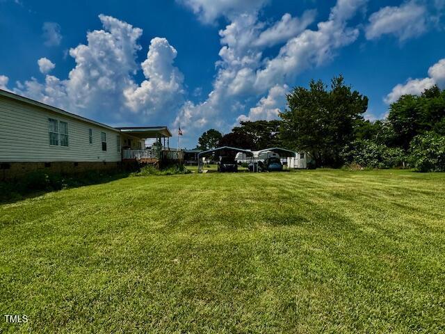 174 Daffodil Dr, Henderson, NC 27537 - view of grassy yard featuring a detached carport