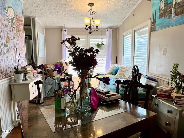174 Daffodil Dr, Henderson, NC 27537 - dining area with crown molding, a textured ceiling, wainscoting, a chandelier, and radiator heating unit