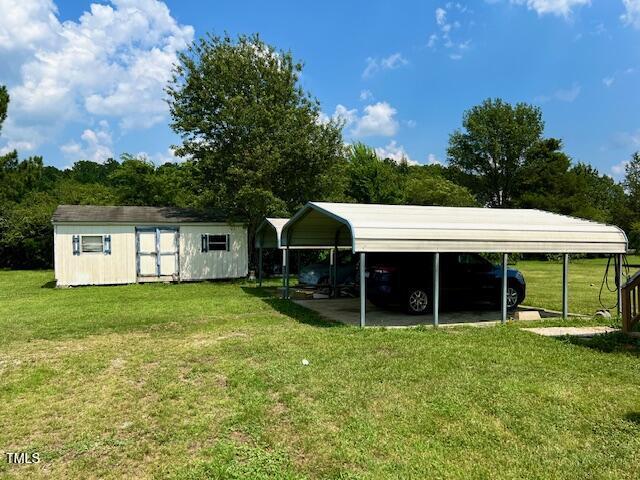 174 Daffodil Dr, Henderson, NC 27537 - back of property with a carport, a shed, and a yard