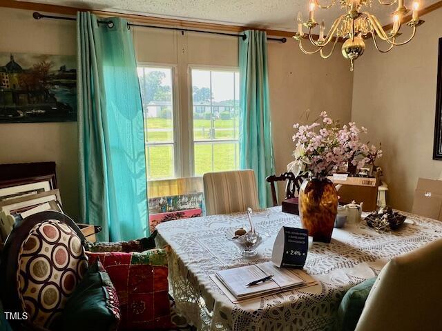 174 Daffodil Dr, Henderson, NC 27537 - dining space with a chandelier and a textured ceiling