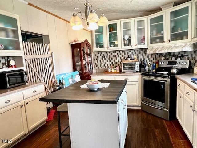 174 Daffodil Dr, Henderson, NC 27537 - kitchen with stainless steel appliances, range hood, a breakfast bar, a textured ceiling, and a center island