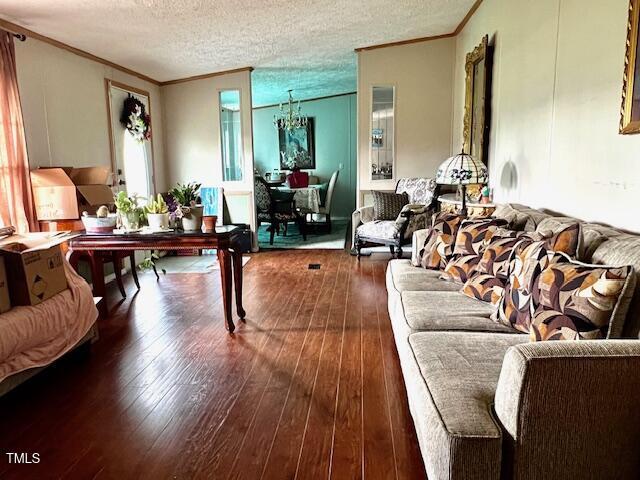 174 Daffodil Dr, Henderson, NC 27537 - living area with crown molding, wood-type flooring, and a textured ceiling