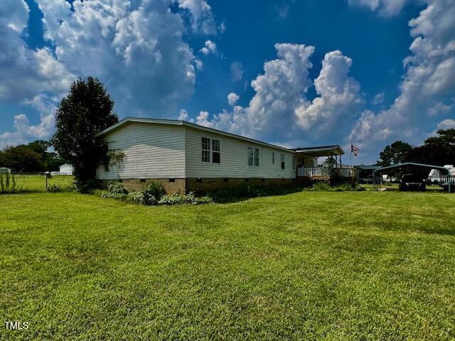 174 Daffodil Dr, Henderson, NC 27537 - view of side of property with crawl space, a yard, and a detached carport