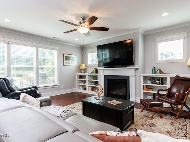 8712 Halsey Ln, Wake Forest, NC 27587 - living room featuring healthy amount of natural light, ornamental molding, wood finished floors, a glass covered fireplace, and a ceiling fan