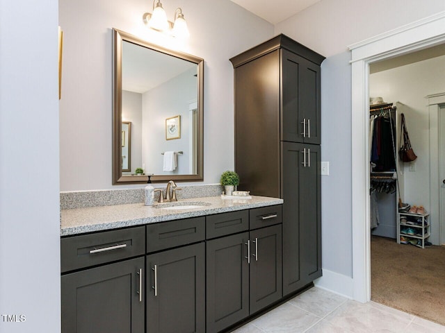 8712 Halsey Ln, Wake Forest, NC 27587 - bathroom featuring vanity, a walk in closet, and tile patterned floors