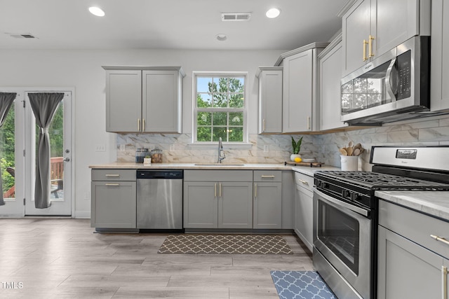 837 Stable Fern Dr, Fuquay Varina, NC 27526 - kitchen with stainless steel appliances, light countertops, decorative backsplash, recessed lighting, and gray cabinets