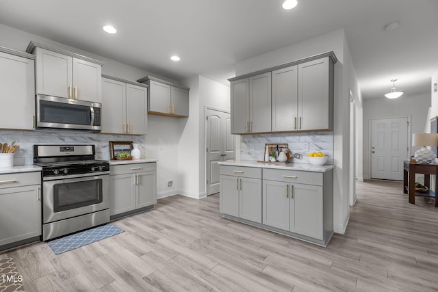 837 Stable Fern Dr, Fuquay Varina, NC 27526 - kitchen featuring stainless steel appliances, gray cabinetry, decorative backsplash, light countertops, and recessed lighting