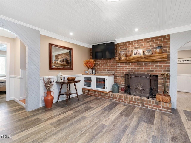 358 Benjie Williams Rd, Staley, NC 27355 - living room with wood finished floors, ornamental molding, wainscoting, arched walkways, and a fireplace