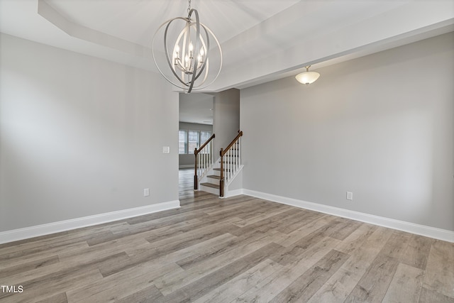 165 Naples Ln, Clayton, NC 27527 - spare room featuring light wood-style floors, a chandelier, stairway, and a raised ceiling