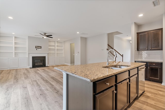 165 Naples Ln, Clayton, NC 27527 - kitchen with a ceiling fan, stainless steel dishwasher, light stone counters, light wood-type flooring, and dark brown cabinetry
