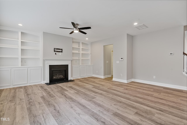 165 Naples Ln, Clayton, NC 27527 - unfurnished living room with a ceiling fan, light wood-type flooring, recessed lighting, a glass covered fireplace, and built in shelves