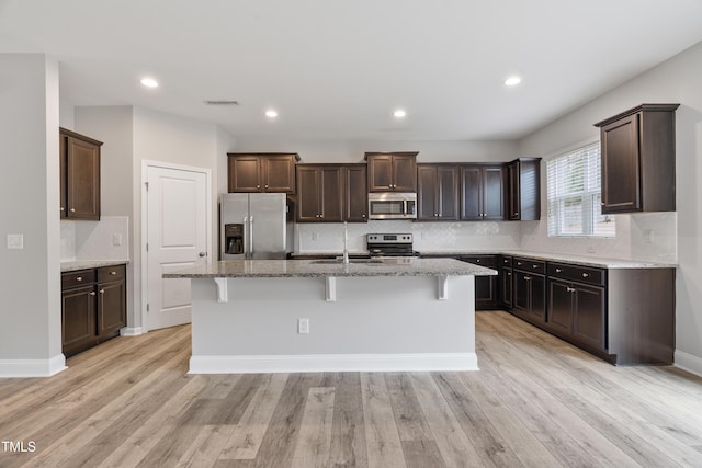 165 Naples Ln, Clayton, NC 27527 - kitchen with stainless steel appliances, dark brown cabinetry, decorative backsplash, and recessed lighting