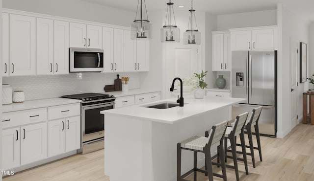 121 N Harvest Ridge Way Unit 262, Wilsons Mills, NC 27520 - kitchen with appliances with stainless steel finishes, light wood-style flooring, tasteful backsplash, and a kitchen island with sink