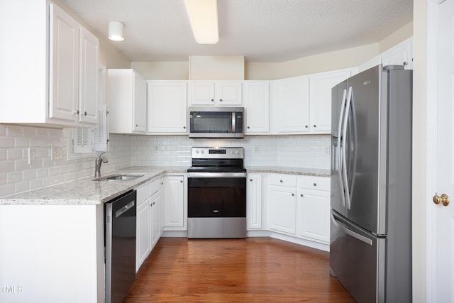 3213 Planet Dr, Raleigh, NC 27604 - kitchen featuring appliances with stainless steel finishes, white cabinetry, light stone countertops, backsplash, and wood finished floors