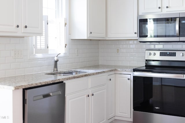3213 Planet Dr, Raleigh, NC 27604 - kitchen with stainless steel appliances, white cabinets, tasteful backsplash, and light stone countertops