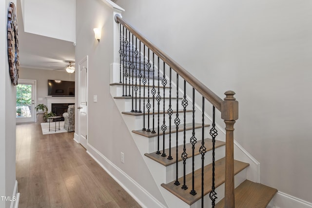 630 Heartland Flyer Dr, Knightdale, NC 27545 - staircase with ceiling fan, wood finished floors, and a fireplace