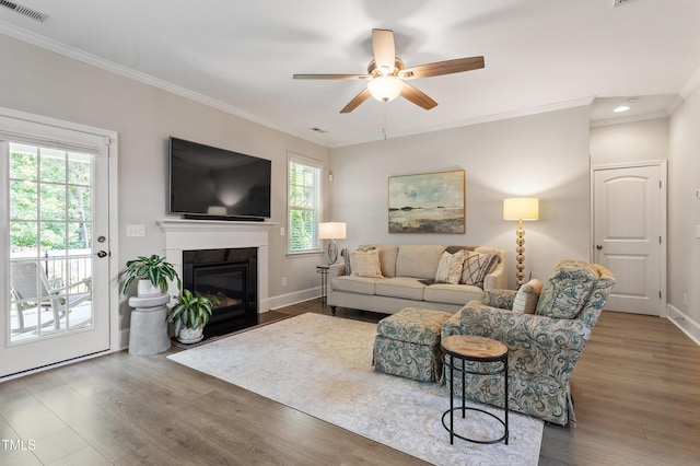 630 Heartland Flyer Dr, Knightdale, NC 27545 - living room featuring wood finished floors, ornamental molding, a ceiling fan, a fireplace with flush hearth, and recessed lighting