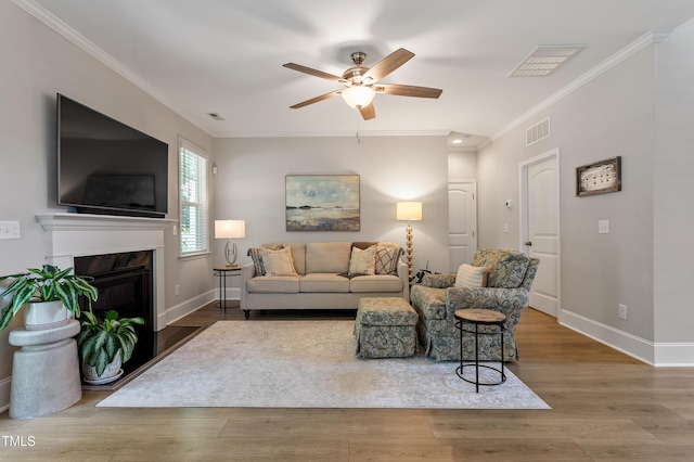 630 Heartland Flyer Dr, Knightdale, NC 27545 - living area featuring a ceiling fan, crown molding, wood finished floors, and a high end fireplace