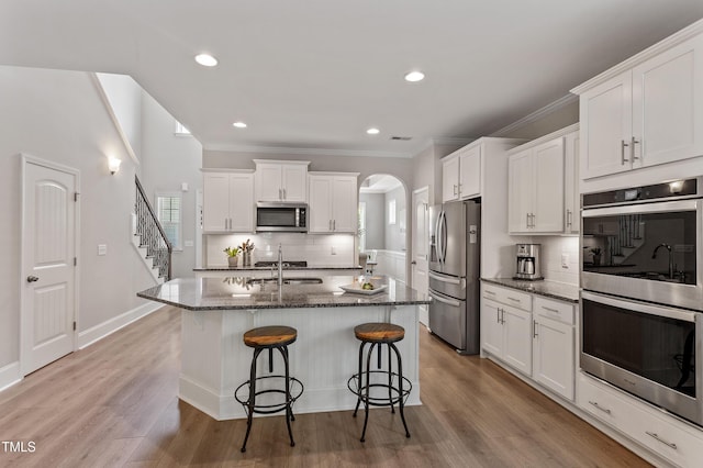 630 Heartland Flyer Dr, Knightdale, NC 27545 - kitchen featuring stainless steel appliances, backsplash, dark stone countertops, a kitchen breakfast bar, and white cabinets