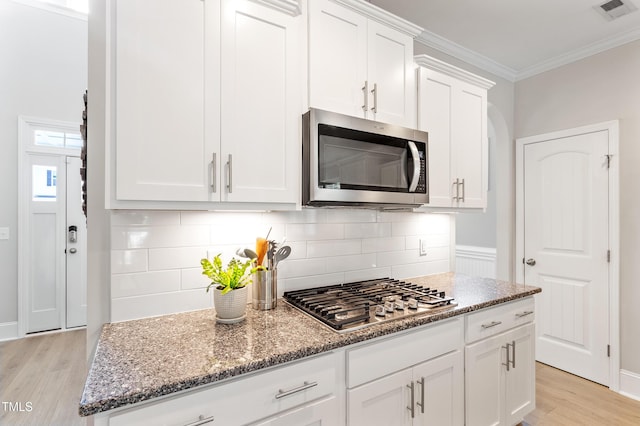 630 Heartland Flyer Dr, Knightdale, NC 27545 - kitchen featuring appliances with stainless steel finishes, light wood-type flooring, decorative backsplash, light stone counters, and white cabinets