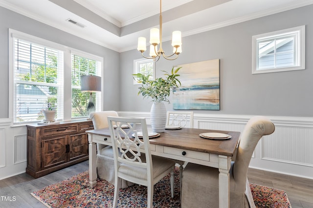 630 Heartland Flyer Dr, Knightdale, NC 27545 - dining space featuring wainscoting, a chandelier, wood finished floors, ornamental molding, and a decorative wall