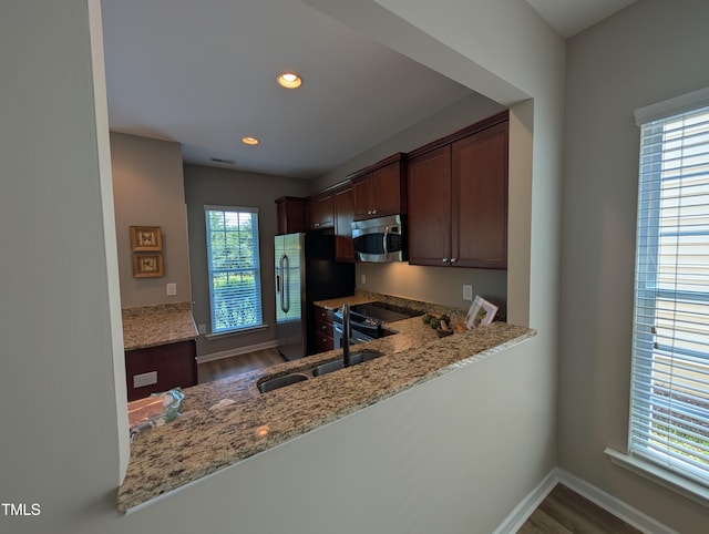 4221 Del Webb Ave, Cary, NC 27519 - kitchen with stainless steel appliances, light stone countertops, wood finished floors, and recessed lighting