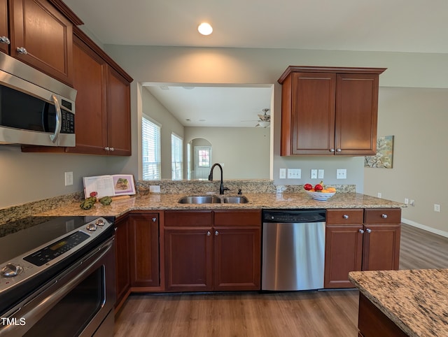 4221 Del Webb Ave, Cary, NC 27519 - kitchen featuring appliances with stainless steel finishes, wood finished floors, and light stone countertops