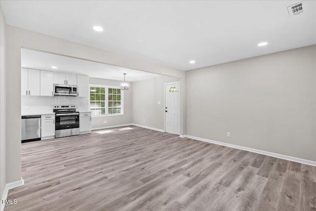 691 Oak Grove Rd, Roxboro, NC 27574 - unfurnished living room with a chandelier, light wood-style flooring, and recessed lighting