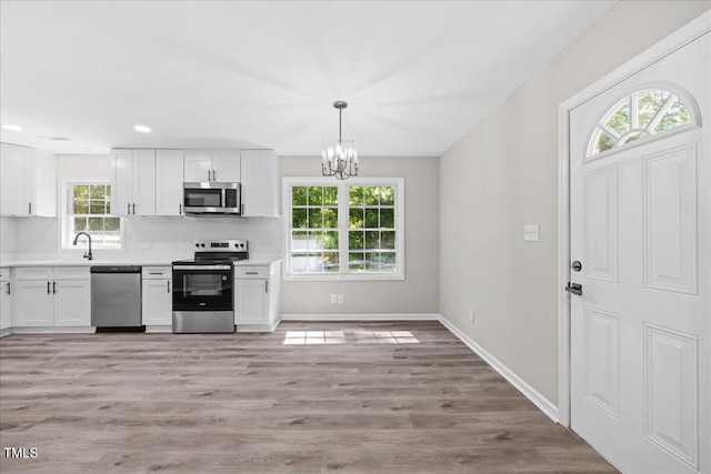 691 Oak Grove Rd, Roxboro, NC 27574 - kitchen with stainless steel appliances, white cabinetry, healthy amount of natural light, a chandelier, and recessed lighting