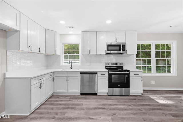 691 Oak Grove Rd, Roxboro, NC 27574 - kitchen with stainless steel appliances, white cabinets, light countertops, decorative backsplash, and recessed lighting