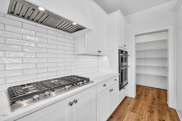 6928 Will Let Ln, Wake Forest, NC 27587 - kitchen with custom range hood, stainless steel appliances, ornamental molding, light countertops, and tasteful backsplash