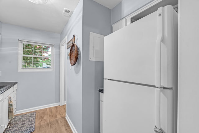 6311 New Market Way, Raleigh, NC 27615 - kitchen with freestanding refrigerator, dark countertops, light wood-style flooring, and white cabinetry