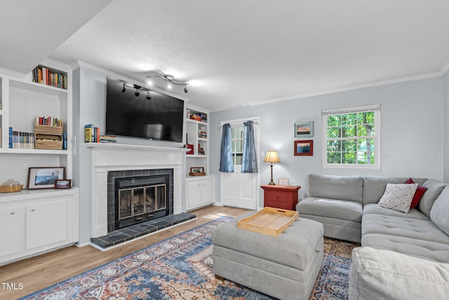 6311 New Market Way, Raleigh, NC 27615 - living area with wood finished floors, crown molding, a fireplace, built in shelves, and a textured ceiling