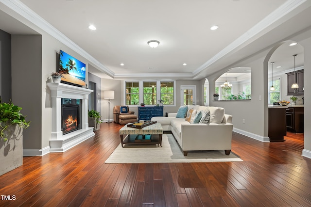 5116 Trembath Ln, Cary, NC 27519 - living area with wood-type flooring, plenty of natural light, a warm lit fireplace, a raised ceiling, and ornamental molding