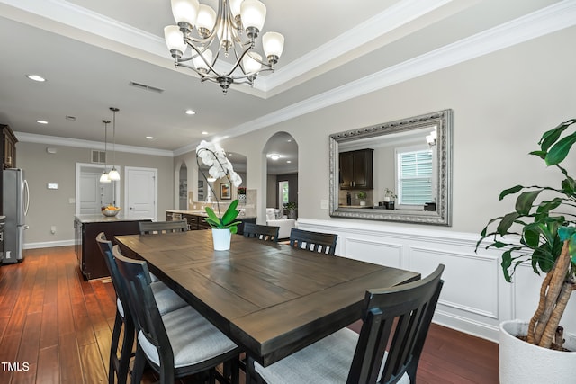 5116 Trembath Ln, Cary, NC 27519 - dining space with arched walkways, dark wood finished floors, a chandelier, crown molding, and recessed lighting