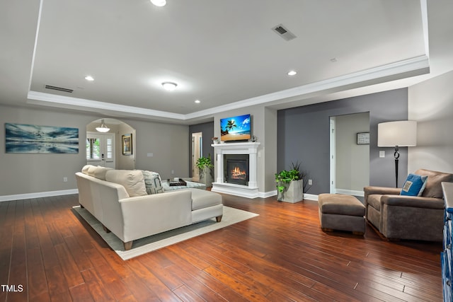 5116 Trembath Ln, Cary, NC 27519 - living room featuring a raised ceiling, crown molding, a glass covered fireplace, wood-type flooring, and recessed lighting