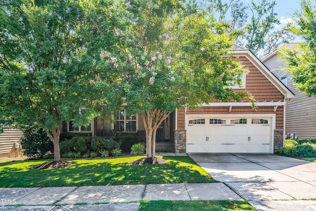 5116 Trembath Ln, Cary, NC 27519 - obstructed view of property featuring stone siding, concrete driveway, a garage, and a front lawn