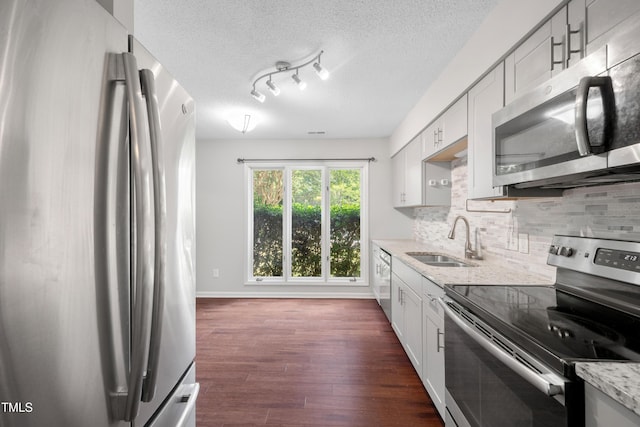 122 Woodbridge Ln, Chapel Hill, NC 27514 - kitchen featuring stainless steel appliances, decorative backsplash, light stone counters, dark wood-type flooring, and a textured ceiling