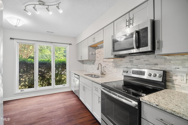 122 Woodbridge Ln, Chapel Hill, NC 27514 - kitchen with appliances with stainless steel finishes, light stone countertops, a textured ceiling, backsplash, and dark wood-type flooring