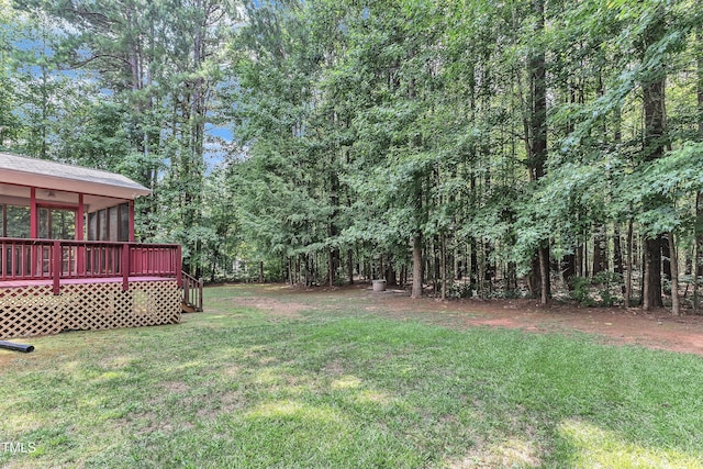 2103 Troys Trl, Franklinton, NC 27525 - view of grassy yard featuring a deck, a forest view, and a sunroom